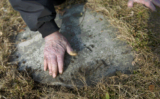 Dick Roberts wipes an old tombstone Dick Roberts wipes an old tombstone