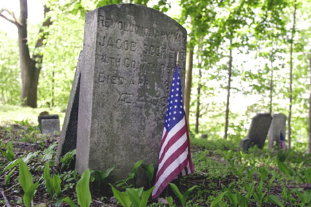 A flag honors the grave of Revolutionary War veteran Jacob Scofield Jr. A flag honors the grave of Revolutionary War veteran Jacob Scofield Jr. in a small, historic burial ground known as Simsbury Cemetery at High Ridge Road and Cross Road in Stamford.