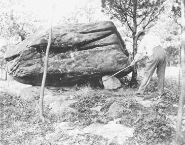 Mr. Delap trying to pull out the small boulder from underneath the big one